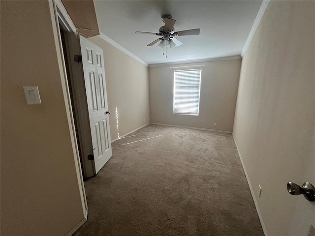 empty room featuring ceiling fan, crown molding, and light carpet