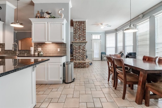 kitchen with pendant lighting, tasteful backsplash, white cabinetry, and ceiling fan