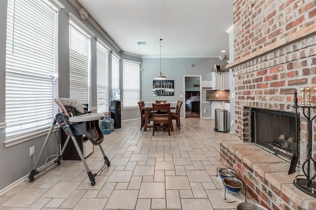 dining room featuring ornamental molding and a brick fireplace