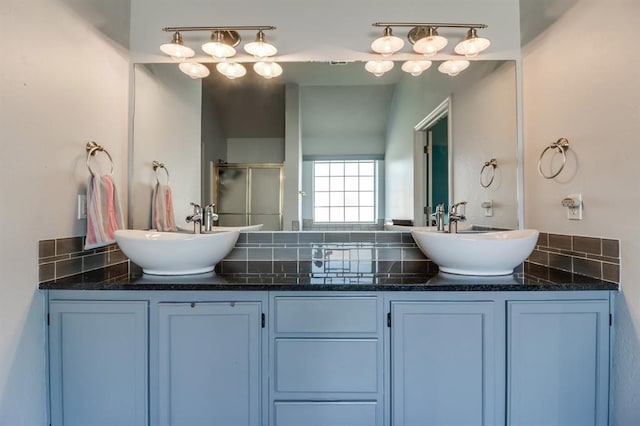 bathroom with backsplash, vanity, and walk in shower