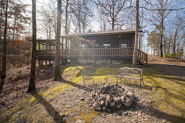 back of property featuring an outdoor fire pit and a wooden deck