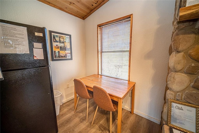 dining space featuring hardwood / wood-style flooring, vaulted ceiling, and wooden ceiling