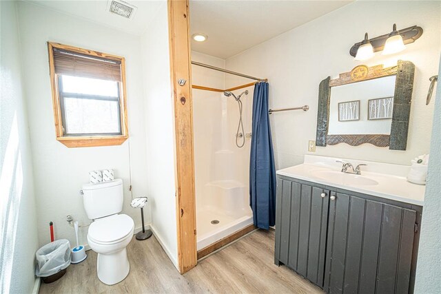 bathroom featuring toilet, vanity, hardwood / wood-style floors, and a shower with shower curtain