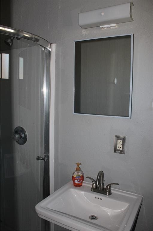 bathroom with sink, a wall mounted AC, and walk in shower