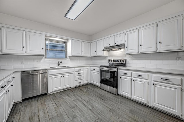 kitchen with white cabinets, appliances with stainless steel finishes, decorative backsplash, and sink