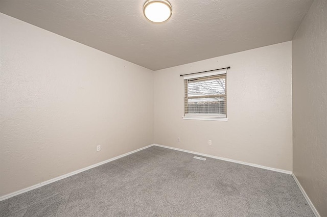 carpeted spare room featuring a textured ceiling