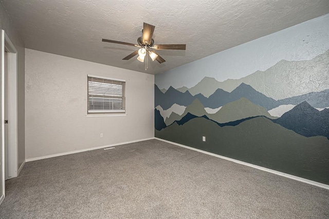 carpeted empty room featuring ceiling fan and a textured ceiling