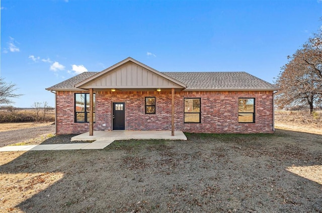 view of front of house featuring a patio and a front lawn