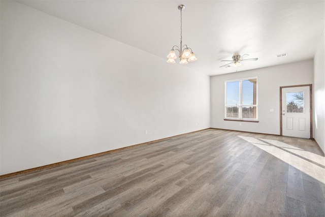 spare room with hardwood / wood-style floors and ceiling fan with notable chandelier