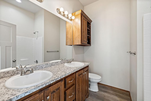 bathroom with toilet, vanity, wood-type flooring, and walk in shower