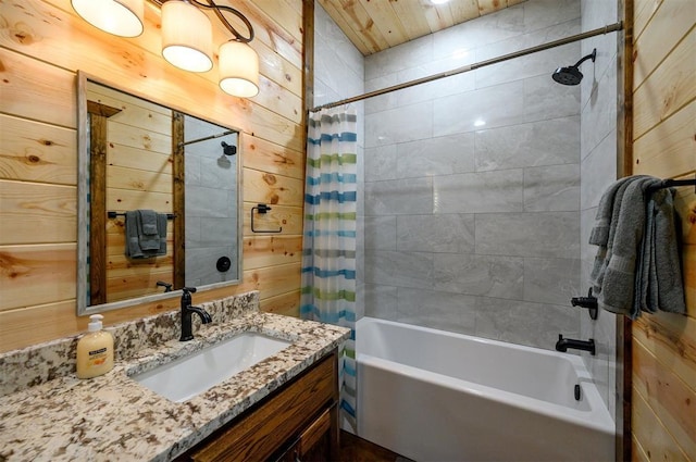 bathroom with shower / bath combo, vanity, and wood walls