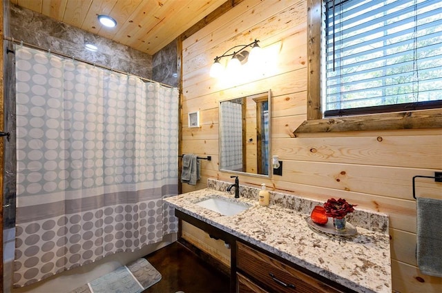 bathroom with a shower with shower curtain, vanity, wooden ceiling, and wooden walls