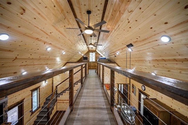 hallway with lofted ceiling, wooden ceiling, and wooden walls