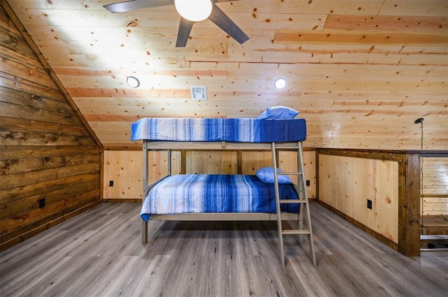 bedroom featuring wood ceiling, vaulted ceiling, ceiling fan, hardwood / wood-style flooring, and wood walls