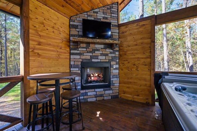 interior space with an outdoor stone fireplace, wooden ceiling, and lofted ceiling