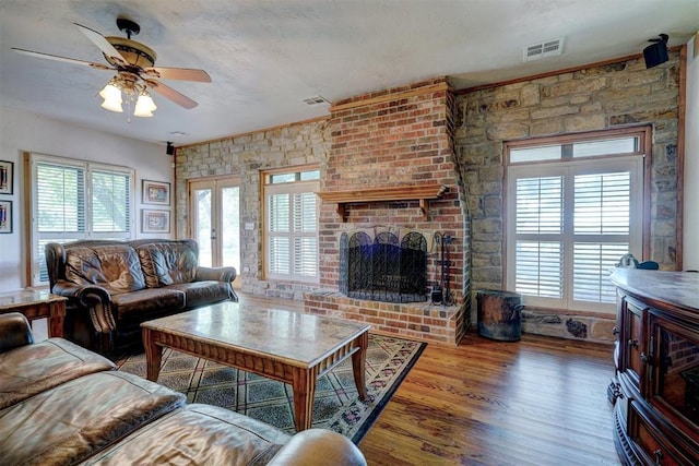 living room featuring a fireplace, ceiling fan, hardwood / wood-style floors, and a healthy amount of sunlight