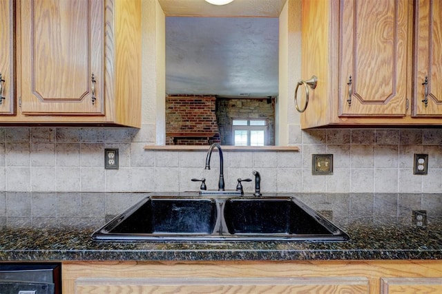 kitchen with tasteful backsplash, sink, and dark stone counters