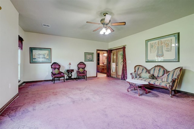 living area with ceiling fan and light colored carpet