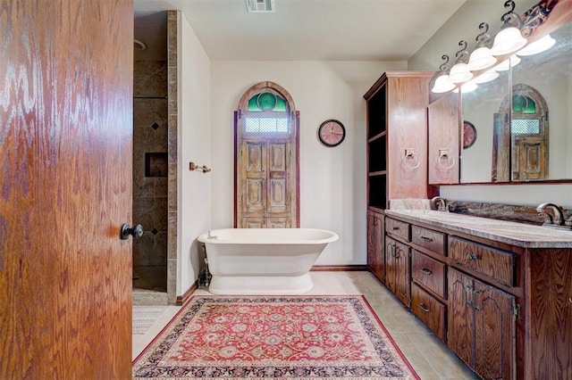 bathroom featuring shower with separate bathtub, vanity, and tile patterned floors