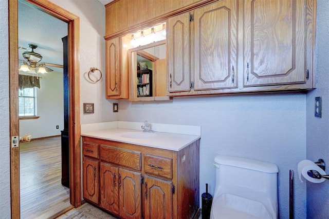 bathroom featuring ceiling fan, toilet, and vanity