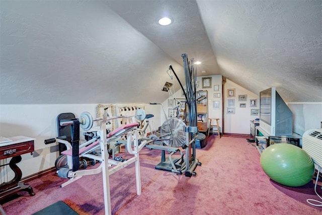 exercise room with a textured ceiling, carpet floors, and vaulted ceiling