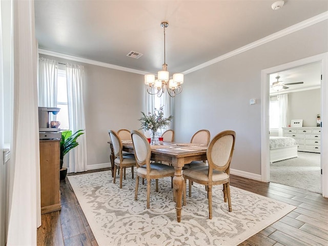 dining room with wood-type flooring, ceiling fan with notable chandelier, and crown molding