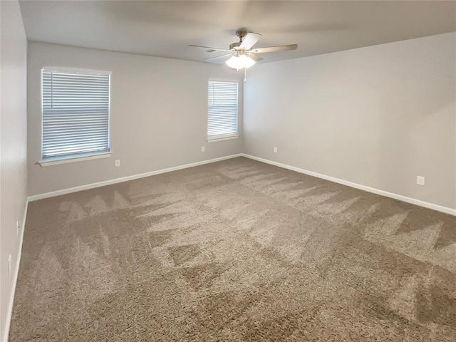 carpeted spare room with ceiling fan