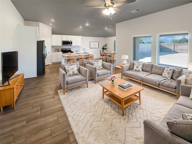 living room featuring ceiling fan and sink