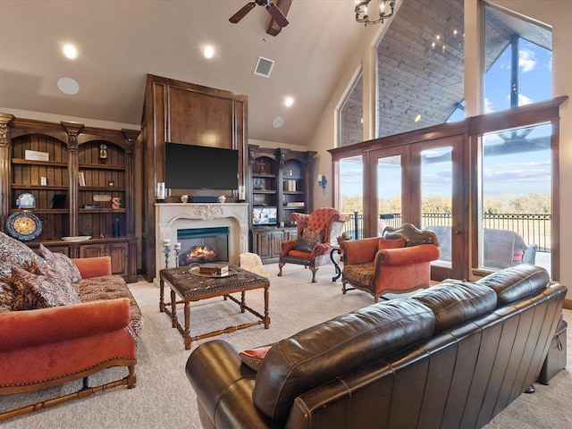 carpeted living room with high vaulted ceiling and ceiling fan