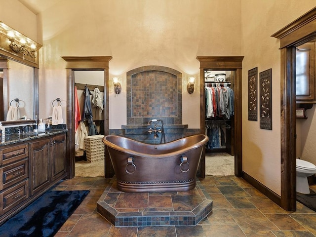 bathroom featuring a bathing tub, a towering ceiling, and vanity