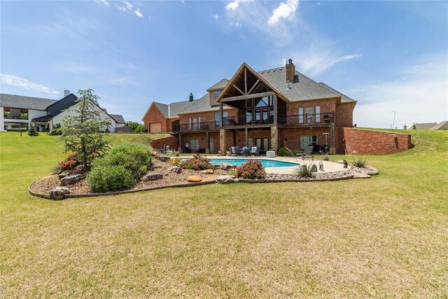5451 Cottonwood Creek Cir, Norman, OK 73069 - back of property with a balcony, brick siding, a lawn, a patio, and an outdoor pool