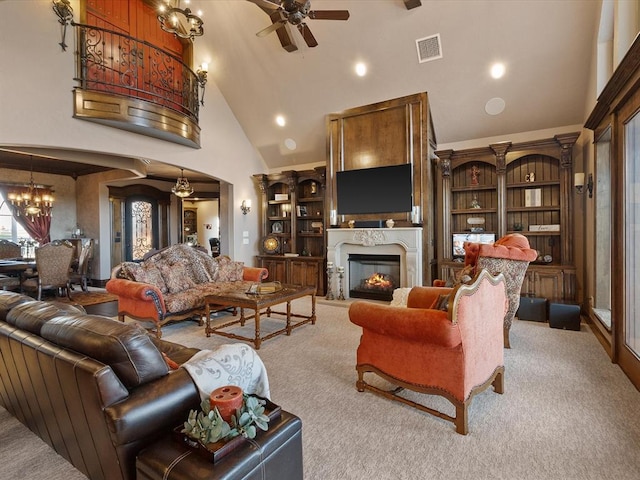 5451 Cottonwood Creek Cir, Norman, OK 73069 - carpeted living room with high vaulted ceiling, arched walkways, a ceiling fan, a glass covered fireplace, and a chandelier