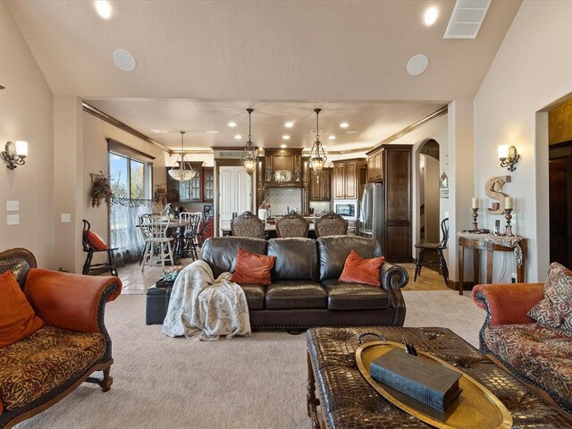 5451 Cottonwood Creek Cir, Norman, OK 73069 - living room with arched walkways, ornamental molding, light colored carpet, vaulted ceiling, and recessed lighting