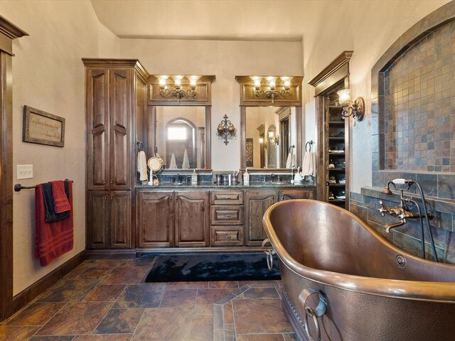 5451 Cottonwood Creek Cir, Norman, OK 73069 - full bath with a freestanding bath, a closet, stone finish flooring, baseboards, and double vanity