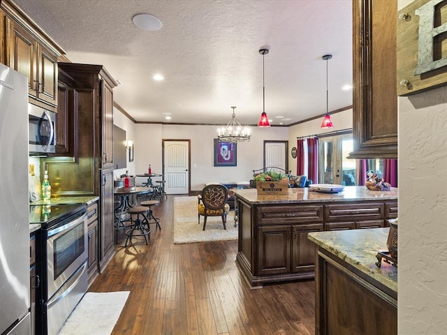 5451 Cottonwood Creek Cir, Norman, OK 73069 - kitchen with stainless steel appliances, stone counters, dark wood finished floors, a chandelier, and ornamental molding