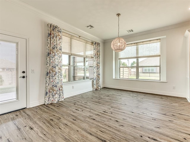 unfurnished dining area with hardwood / wood-style floors and ornamental molding