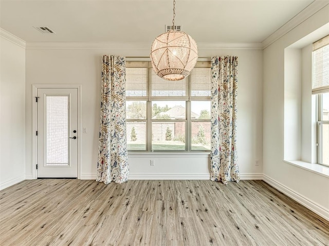 unfurnished dining area featuring light hardwood / wood-style flooring and crown molding