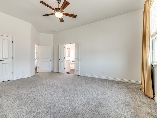 unfurnished bedroom with ceiling fan, light colored carpet, and ensuite bath