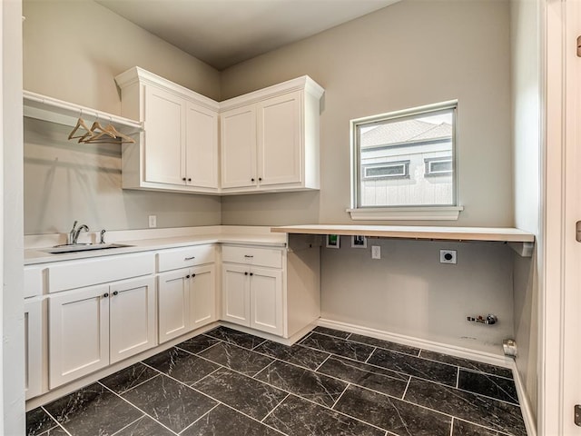 clothes washing area with gas dryer hookup, sink, cabinets, and hookup for an electric dryer