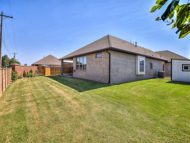 back of house with central AC and a yard