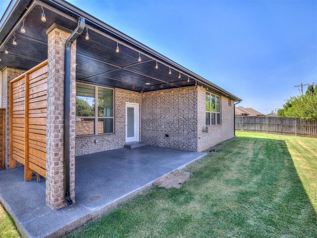 back of property with a patio area and a lawn