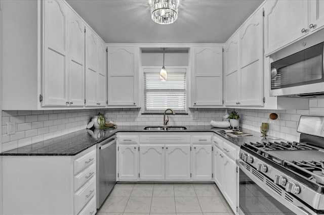 kitchen featuring white cabinets, dark stone countertops, sink, and stainless steel appliances