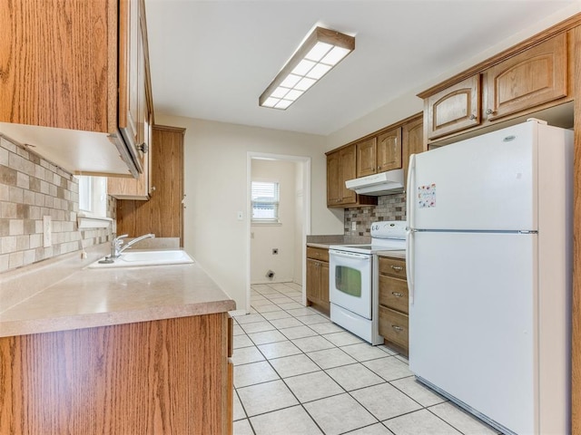 kitchen with sink, white appliances, backsplash, a healthy amount of sunlight, and light tile patterned flooring