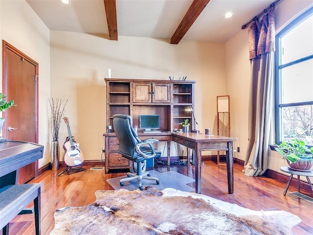 office with beam ceiling and light hardwood / wood-style flooring