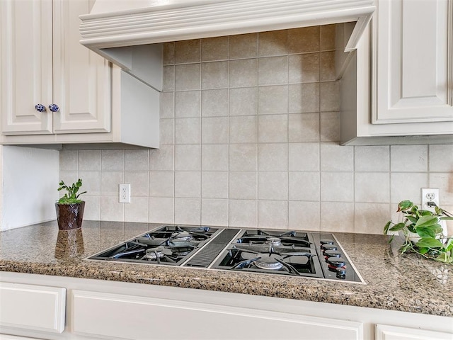 kitchen with white cabinets, decorative backsplash, stone countertops, and stainless steel gas cooktop