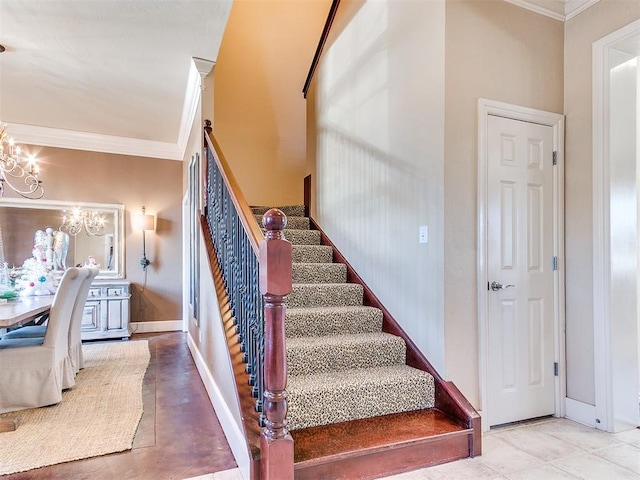 stairs with ornamental molding and an inviting chandelier