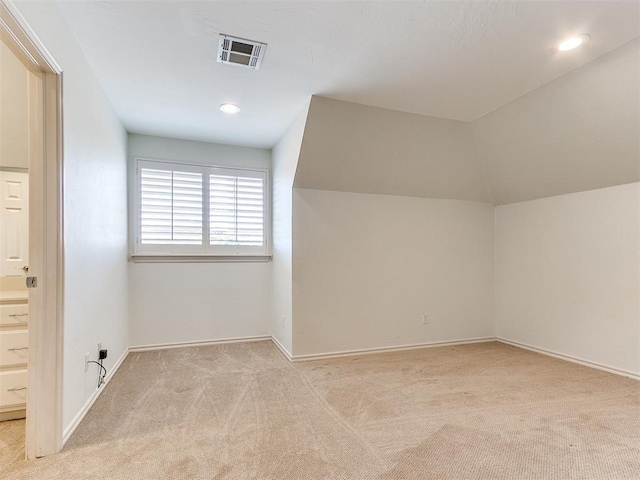 bonus room featuring light carpet and vaulted ceiling