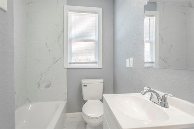 full bathroom featuring tiled shower / bath, vanity, and toilet