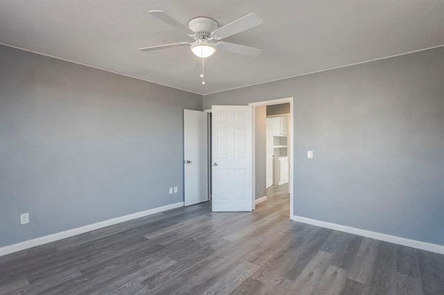 empty room with ceiling fan and dark hardwood / wood-style floors