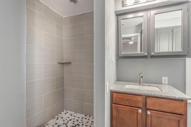 bathroom featuring vanity and tiled shower